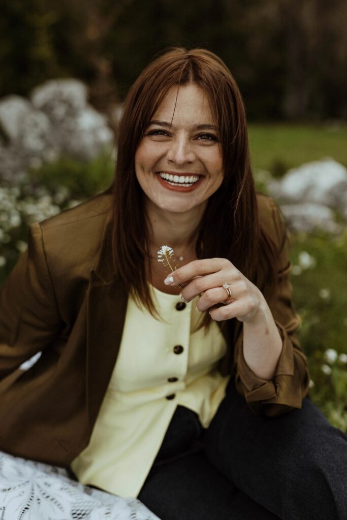 Ivana Strasser von siworxx lacht in die Kamera und hält ein Gänseblümchen – Interior Designerin aus Hemishofen für barrierefreies Design im Bodenseeraum